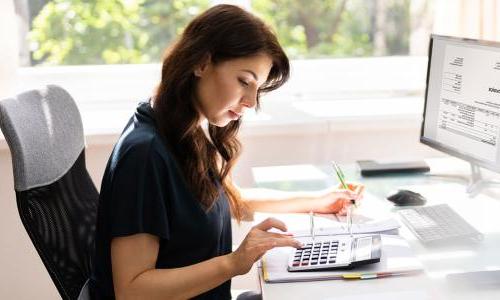 Accountant Seated at Desk Calculating Balances 